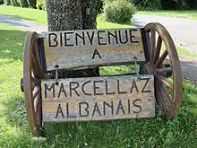 Photographie en couleurs du panneau de bienvenue à l’entrée du chef-lieu de la commune.