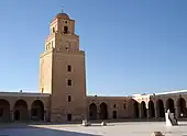 Vue du minaret depuis la cour. La face sud du premier niveau est percée, au-dessus de la porte, de trois fenêtres superposées de forme rectangulaire, qui n'ont pas les mêmes dimensions.
