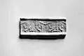 Impression sur argile d'un sceau-cylindre du type élaboré, représentant un génie ailé maîtrisant des animaux, des animaux combattants, des motifs floraux et des disques ailés, Walters Art Museum.