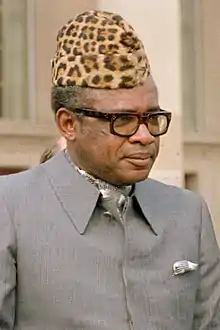 photo portrait d'un homme coiffé d'une toque en peau de léopard, portant lunettes