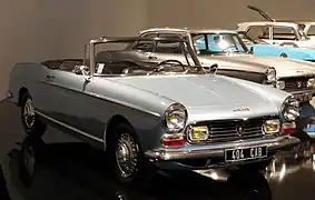 Une 404 cabriolet 2e série, avec l'avant redessiné, les deux optiques supplémentaires intégrées dans la nouvelle calandre et des blocs de clignotant plus volumineux et rectangulaires.
