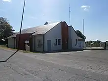 Photographie en couleurs d'un bâtiment récent avec garages partiellement peints en rouge