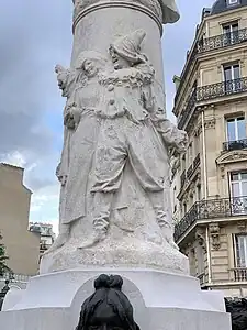 Détail des personnages du Carnaval de Paris à la base de la colonne.