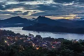 Montagnes, Mékong et habitations éclairées, vues du Mont Phou Si, au crépuscule du soir, à Luang Prabang. Septembre 2023.
