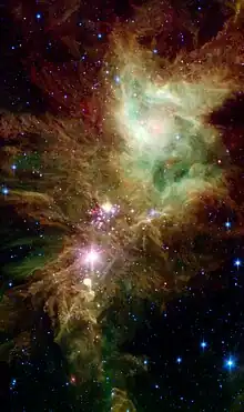 NGC 2264 en infrarouge par le télescope spatial Spitzer. En rose, des étoiles nouvellement formées. On a donné le nom d'amas du Flocon de Neige (en) au groupe d'étoiles que l'on voit sur cette photo.
