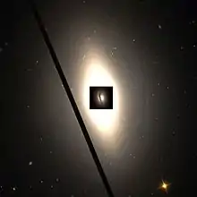 NGC 4435 et l'anneau de poussières autour de son noyau photographié par le télescope spatial Hubble, largeur 1,8′ d'angle.