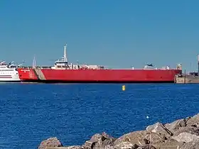 Un navire de couleur rouge dans un port.