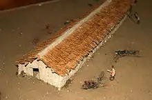 Photo d'une maquette reconstitutant une ferme néolithique. Les toits sont en chaume