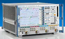 appareil de mesure sur une paillasse. Écran plat, nombreux boutons, quatre prises coaxiales.