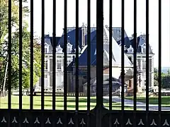 Derrière la grille, le château du Grand Chavanon masque en partie le château de Saint-Hubert.
