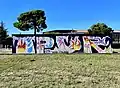 Graffiti de OPUR, pièce picturale s'intégrant dans le street art par le mélange de lettres et de motifs colorés.