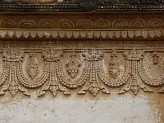 Faces monstrueuses apotropaïques crachant des anses perlées