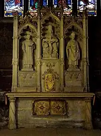 Autel néogothique avec trois statues Saint Vincent, Trinité, Saint Germain, formant retable (XIXe siècle).