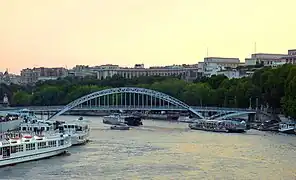 La passerelle le soir, avec le Trocadéro (arbres des jardins du Trocadéro et palais de Chaillot) au fond.