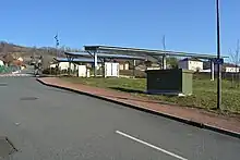 La rue du Treuil avec un poste électrique et des panneaux photovoltaïques au-dessus d'un parking