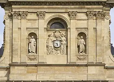 Détail de la façade. À gauche, la statue de Saint Thomas d'Aquin, à droite celle de Pierre Lombard. Au centre, deux statues de muse soutiennent l'horloge, surmontée des armoiries du cardinal de Richelieu.