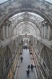 Arcade décorée, verrières, passerelles à rambarde, colonnes : le passage dans sa plus grande longueur.