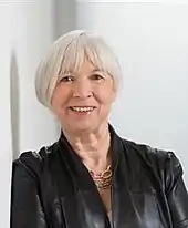 Photo d'une femme souriante aux cheveux blancs.