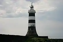 Vue en couleur d'un phare orné de deux bandes horizontales blanches.