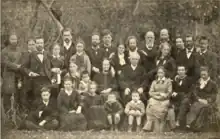 Photographie de Jacques et Zéline Reclus (assis au centre de la photographie) entourés de leur onze enfants et d'autres membres de leur famille (1881).