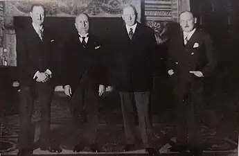 Photographie ancienne en noir et blanc de quatre hommes en costume.