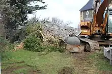 Photo d'une pelleteuse et de gravât de béton.