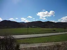 Plaine de la Bléone verdoyante au printemps. Les collines de Chénerilles sont encore noires de l'hiver