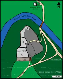 Plan en couleur d'une colline contournée par une rivière d'ouest en est par le nord. Au sommet de la colline se trouve un plateau avec plusieurs constructions à l'ouest et au nord-ouest et une place sur la partie est. Un chemin d'accès arrive du sud et traverse un fossé pour entrer sur le plateau. Un autre chemin, plus petit, part de l'ouest du plateau et rejoint la rivière à un pont, au nord-ouest de la colline.