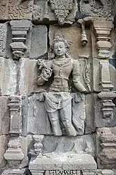 Photographie du bas-relief d'une divinité hindoue en quatre parties : la tête, le buste, les jambes et les pieds.