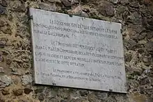 Plaque commémorative fixée sur un mur.