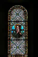 Photographie couleur d'un vitrail montrant saint Benoît en médaillon.