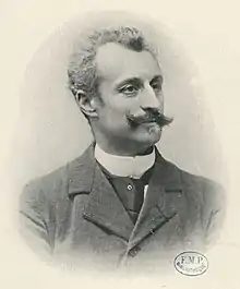 Photo en noir et blanc d'un homme moustachu, de buste.