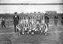 Photographie d'une équipe de football devant un but