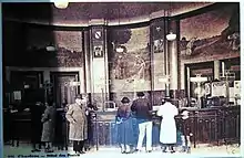 Raoul Brandon devant les guichets de l'hôtel des Postes de Chartres et les peintures murales de Pierre Vaillant.