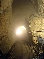 Photographie en couleurs d'un couloir souterrain éclairé