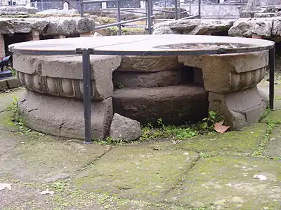 Photographie en couleurs d'une table circulaire en pierre.