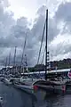 Le trimaran aux côtés des autres voiliers de la flotte sous le regard du public du village départ de la Route du Rhum