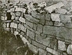Photographie en noir et blanc des vestiges d'un mur d'une église