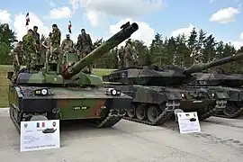 Un Leclerc SXXI français et un Leopard 2A6 du Régiment Skaraborg en démonstration statique lors de la cérémonie d'ouverture de la compétition Strong Europe Tank Challenge, à Grafenwöhr, en juin 2018.