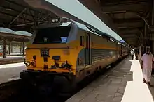 Photo couleur à contre jour montrant une locomotive à quai en gare.