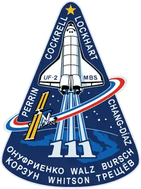 Le logo de la mission STS-111 de la navette spatiale Endeavour vers la Station spatiale internationale en 2002.Les trois « 1 » signifiant le numéro de la mission, de par leur forme verticale, se confondent avec la représentation stylisée des flammes blanches de la navette.