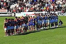 Deux équipes alignées de part et d'autre des arbitres