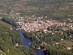 Le village est longé par une rivière et entouré par la végétation.