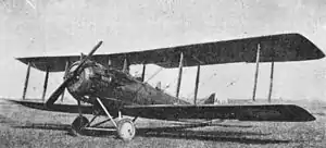 Photographie en noir et blanc d'un avion biplan au sol