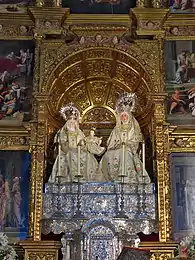 Groupe statuaire représentant deux femmes assises côte à côte, encadrant un jeune enfant.