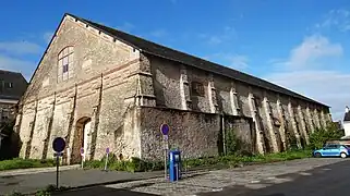 Vue de trois-quarts d’un haut bâtiment de pierres.