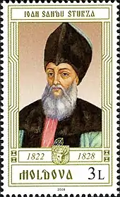 Timbre-poste représentant un homme à la barbe blanche portant un grand chapeau noir.