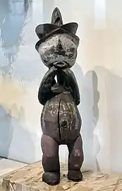 Statue avec coiffe à triple crête.