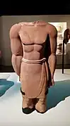Statue d'homme acéphale et brisée à hauteur de genoux, sanctuaire de Dadan (al-Khuraybah).