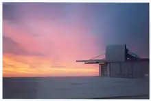 Abri ouvert pour la mise en température du sidérostat au coucher du soleil : le toit a coulissé le long de rails, laissant voir le tube du sidérostat, ajouré pour permettre les échanges thermiques. Des volets ouverts à la base de l'abri accélèrent l'équilibrage thermique.